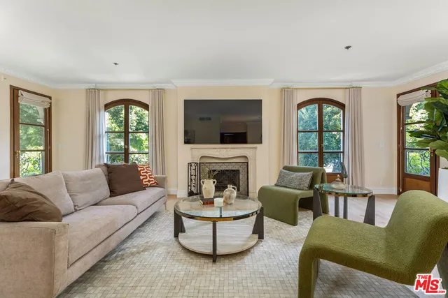 a living room with furniture a fireplace and a large window