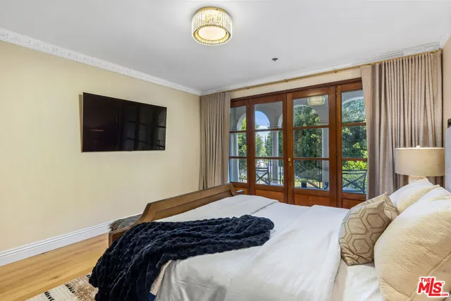 a bedroom with a bed and a flat tv screen next to a window