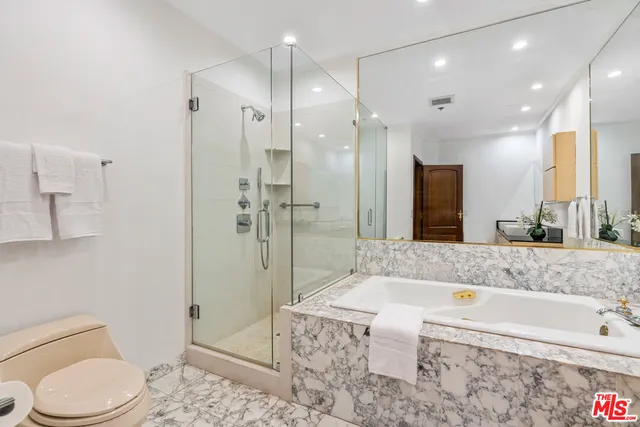 a bathroom with a granite countertop bathtub shower sink and toilet