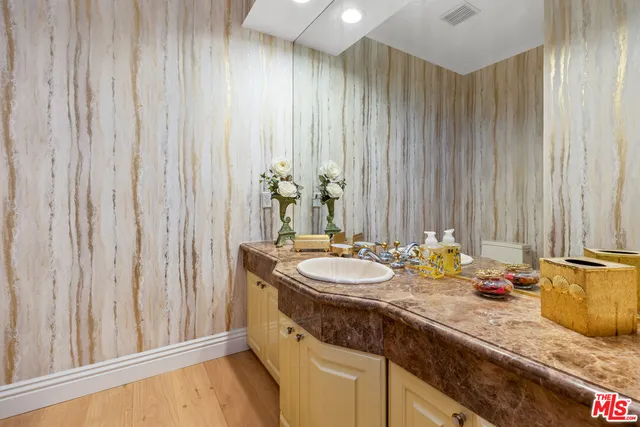 a bathroom with a granite countertop sink and a mirror