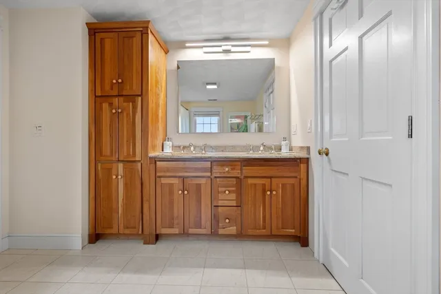 a bathroom with a granite countertop sink and a mirror