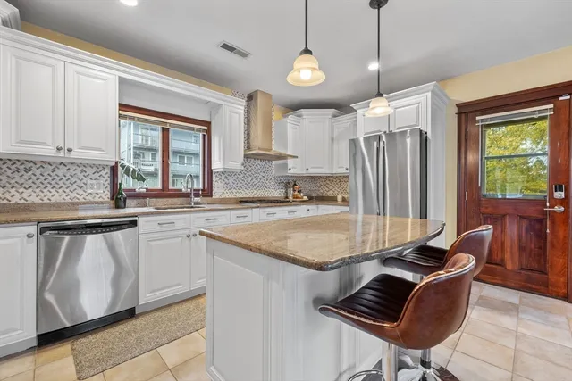 a kitchen with stainless steel appliances granite countertop a sink and a refrigerator