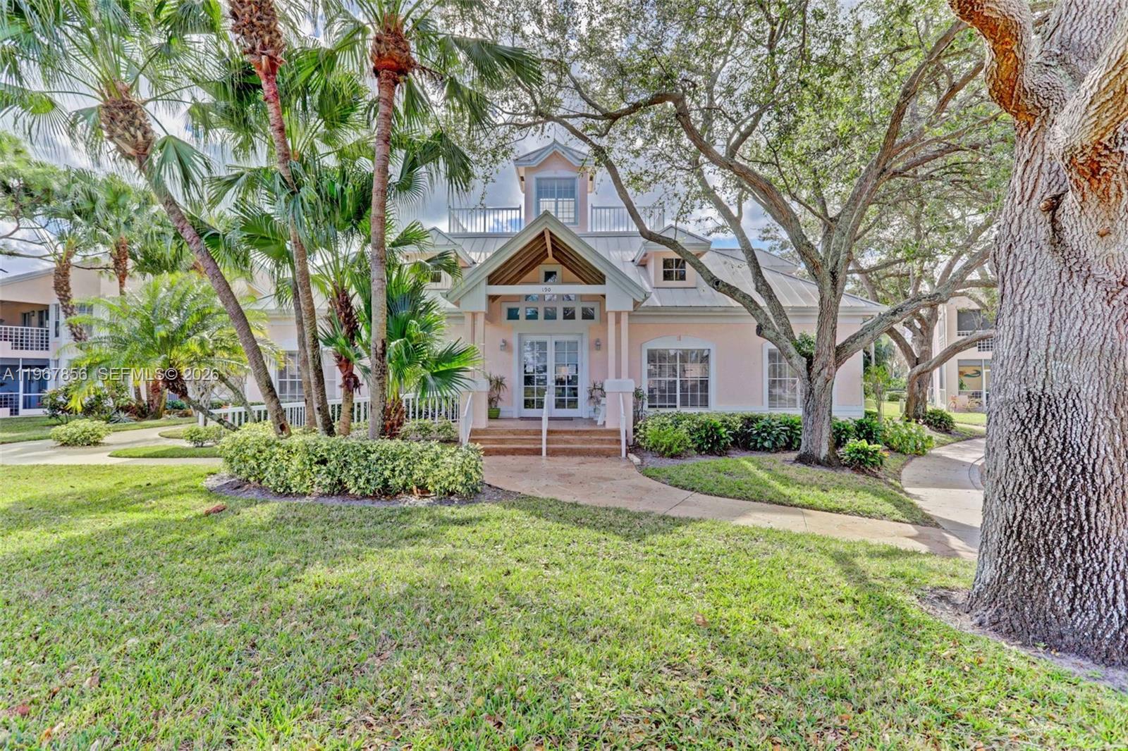 101 Muirfield Court, Unit 101D Jupiter, FL 33458 - Photo 44 of 62 a front view of a house with garden and trees