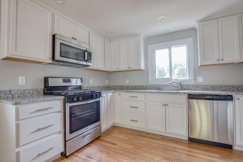 19 Knowlton Road Nashua, NH 03063 - Photo 11 of 35 a kitchen with stainless steel appliances granite countertop a stove a sink and a microwave