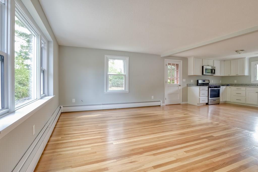 19 Knowlton Road Nashua, NH 03063 - Photo 4 of 35 a view of empty room with wooden floor and kitchen window