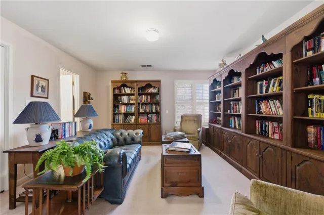 a living room with furniture and a book shelf