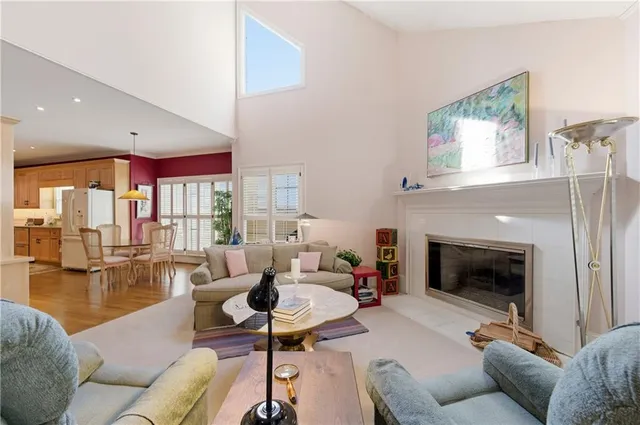 a living room with furniture fireplace and a large window