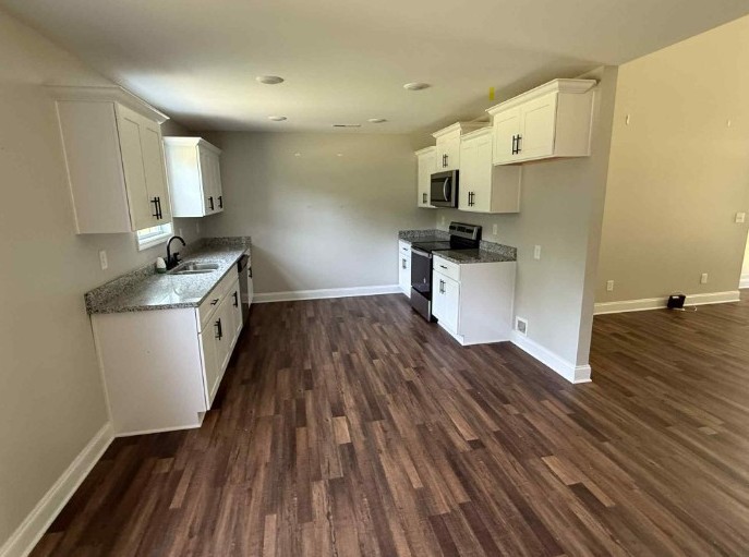 51 Bluff Creek Road Brush Creek, TN 38547 - Photo 11 of 23 a kitchen with wooden floors and white appliances