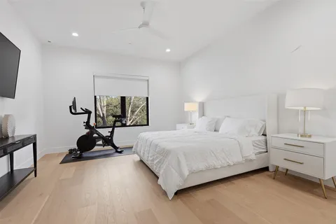a bedroom with a bed a couch and a flat screen tv
