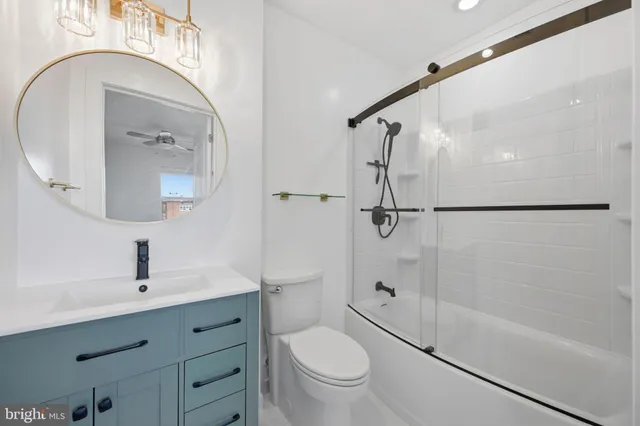 an empty room with wooden floor ceiling fan and windows