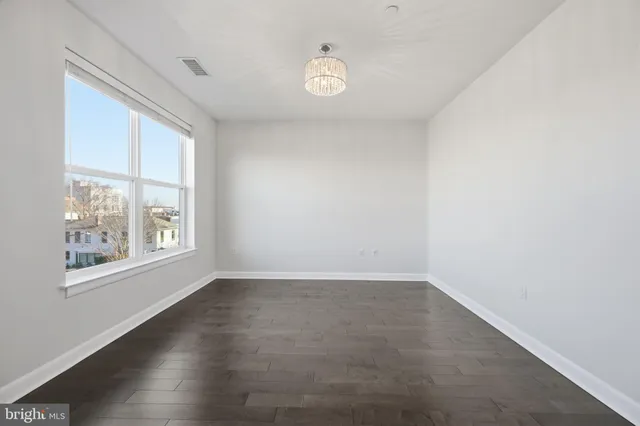 an entryway in a hallway with wooden floor and stairs
