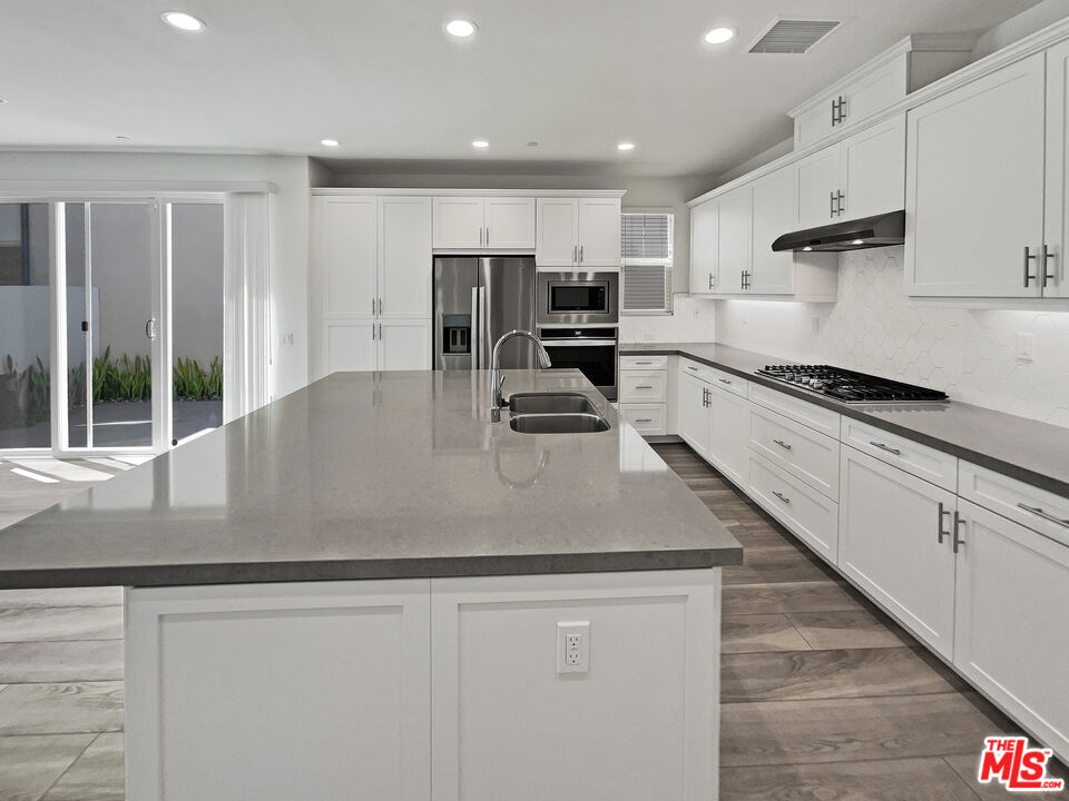 145 Stage Irvine, CA 92618 - Photo 6 of 20 a kitchen with stainless steel appliances granite countertop a sink a stove and a refrigerator