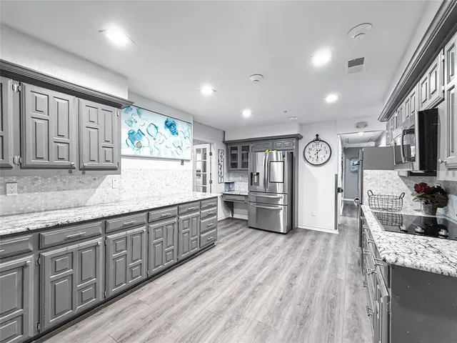 a kitchen with stainless steel appliances kitchen island granite countertop a sink and stove top oven