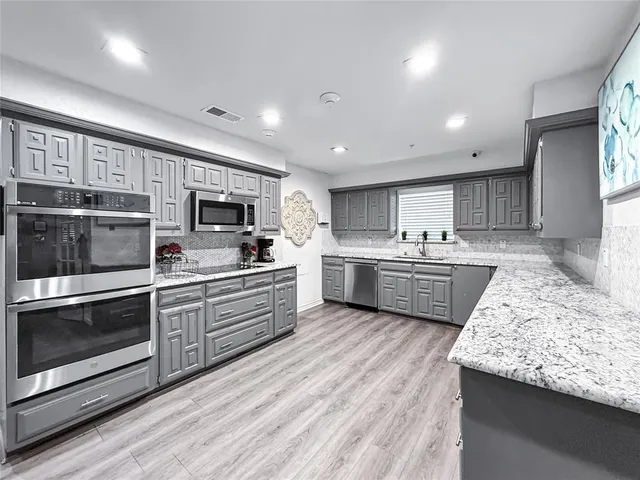 a kitchen with stainless steel appliances granite countertop a stove and cabinets