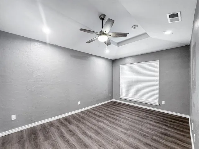 a view of a room with wooden floor and a ceiling fan