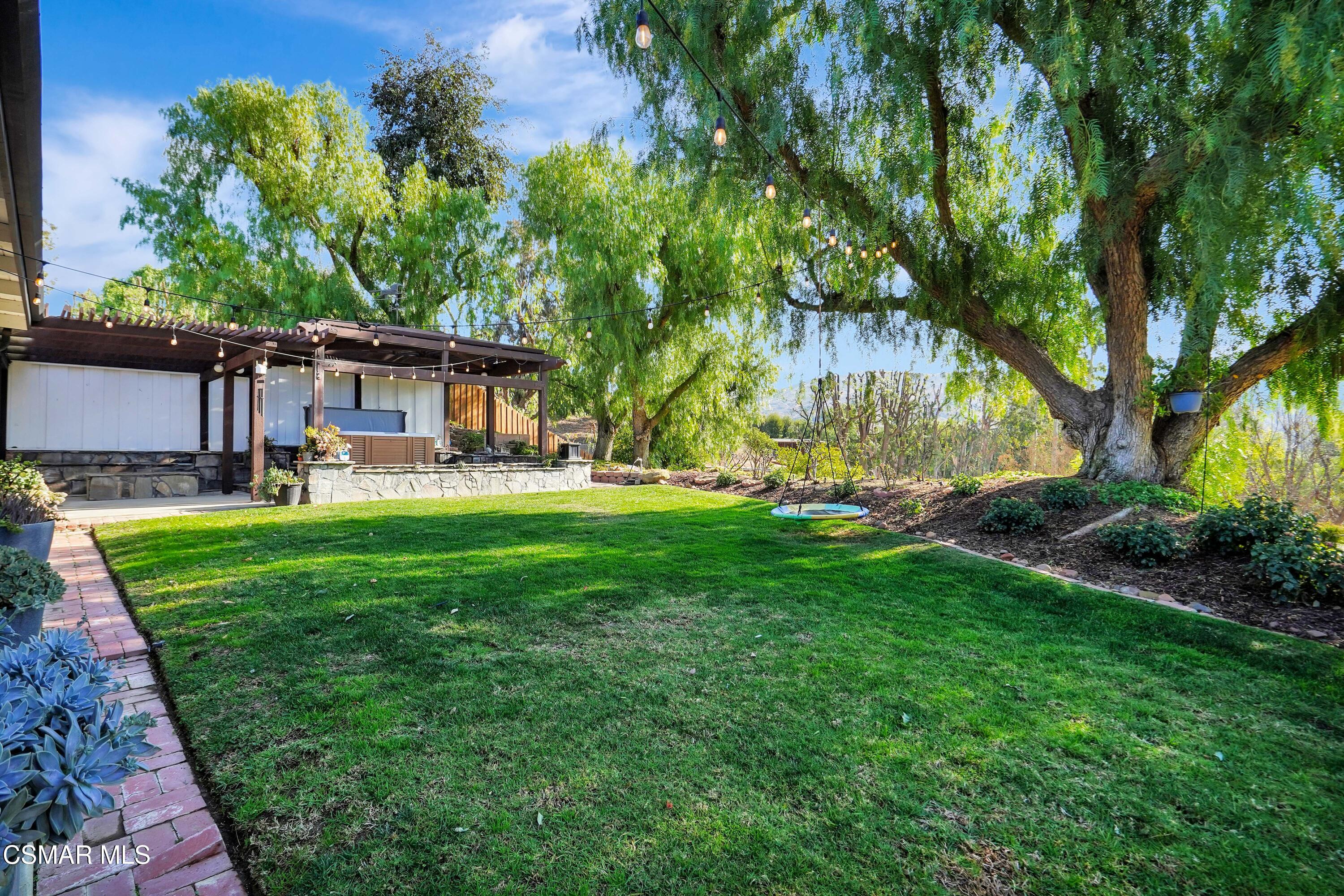 160 Wrangler Road Simi Valley, CA 93065 - Photo 45 of 65 a view of a backyard with table and chairs and potted plants and large trees