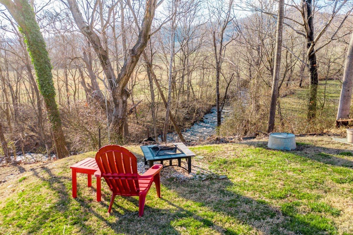 1045 Thrashers Creek Road Amherst, VA 24521 - Photo 48 of 54 a view of a backyard with table and chairs with wooden fence and plants