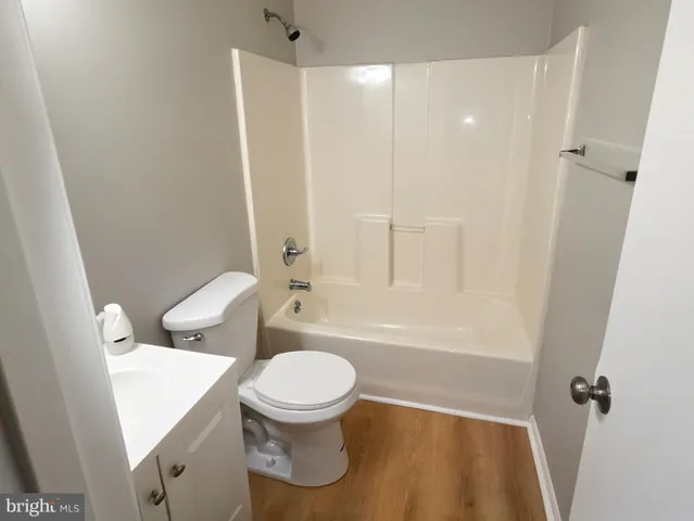 a white toilet sitting next to a bath tub