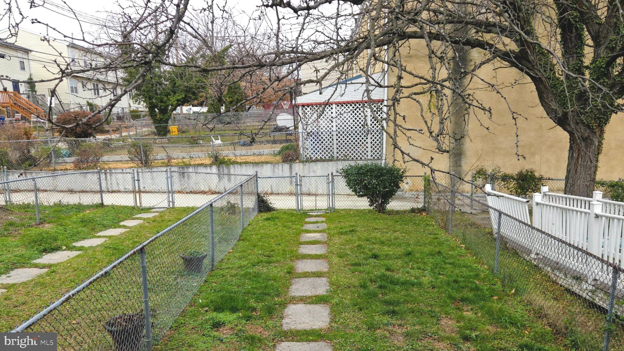 1226 East Chase Street Baltimore, MD 21202 - Photo 35 of 41 Serene backyard with stone pathway and fence.
