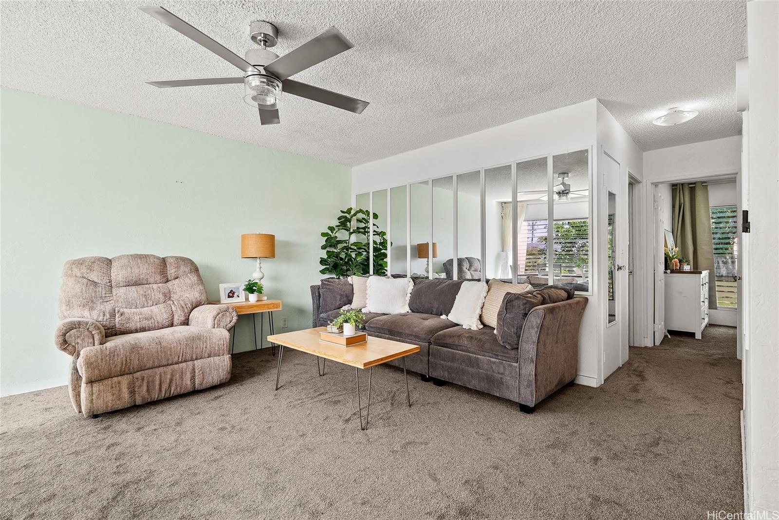 87-122 Helelua Street, Unit C105 Waianae, HI 96792 - Photo 1 of 1 a living room with furniture and a ceiling fan