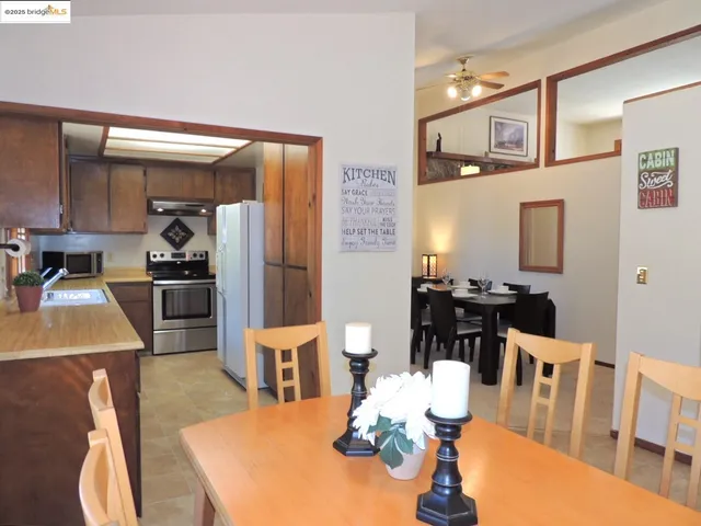 a kitchen with stainless steel appliances a refrigerator a stove and a wooden cabinets