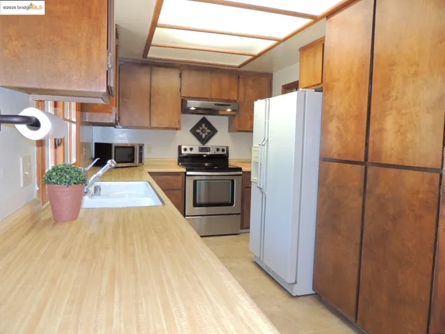 a kitchen with stainless steel appliances granite countertop a refrigerator and a sink