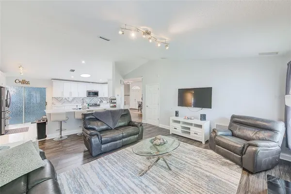 a living room with furniture and a wooden floor