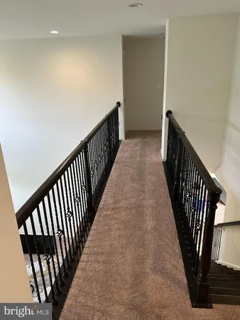 a view of a hallway with wooden floor and stairs