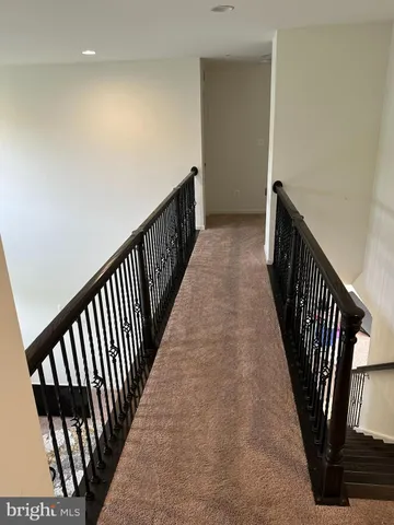 a view of a hallway with wooden floor and stairs