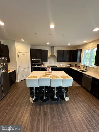 a large kitchen with a center island stainless steel appliances and cabinets