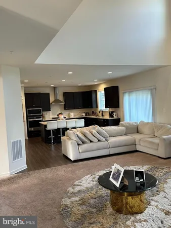 a living room with furniture and kitchen view