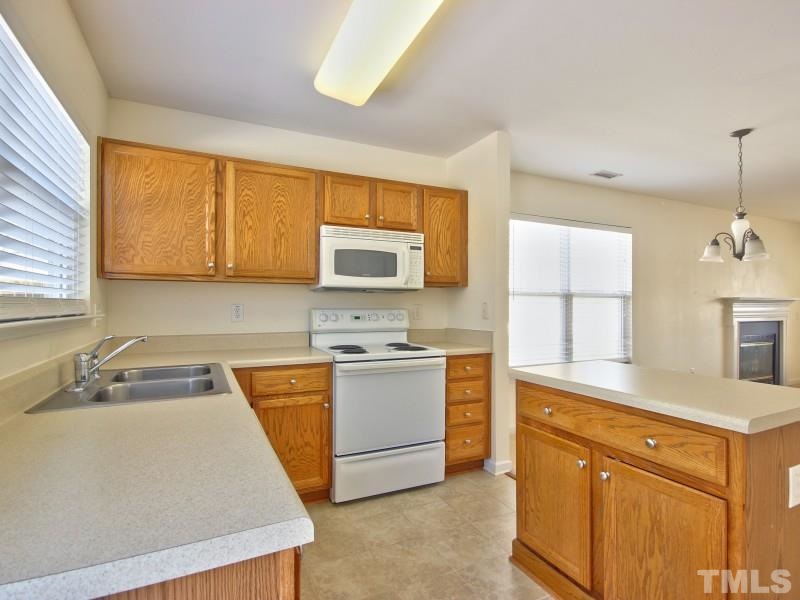 4221 Hopper Street Raleigh, NC 27616 - Photo 8 of 25 a kitchen with a sink a stove and cabinets