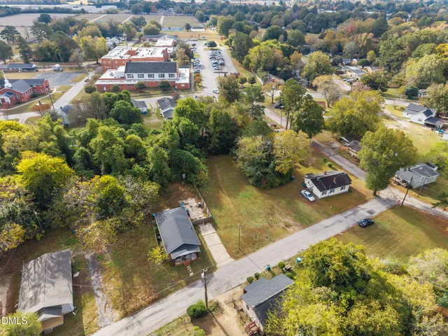 an aerial view of residential houses with outdoor space and trees