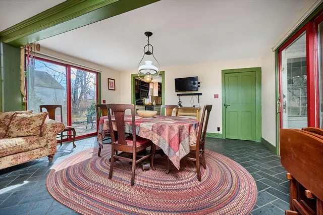 a living room with furniture a large window wooden floor and a rug