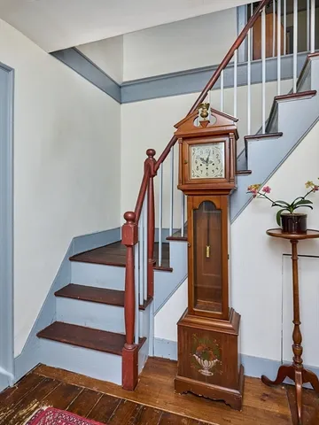a view of entryway with wooden floor and a front door