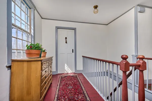a view of a hallway with wooden floor and stairs