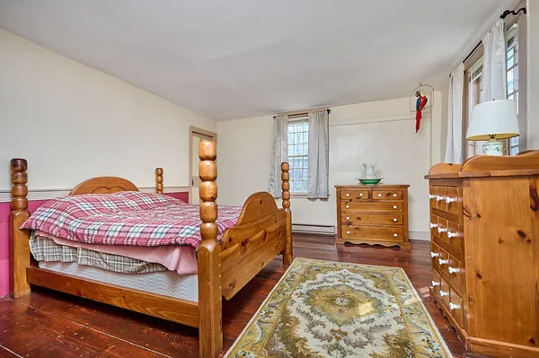 a bedroom with bed and wooden floor