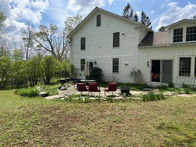 a view of house with backyard and sitting area