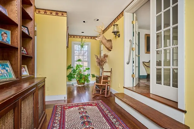 a view of a hallway with wooden floor and staircase