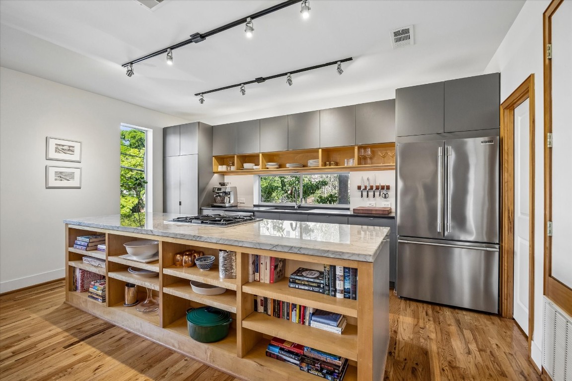 98 Drew Street, Unit A Houston, TX 77006 - Photo 21 of 38 a kitchen with stainless steel appliances a refrigerator and wooden floor