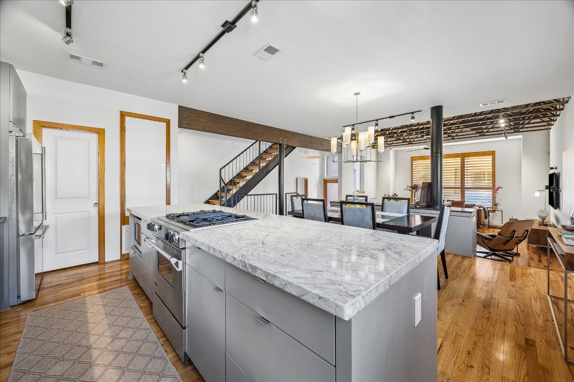 98 Drew Street, Unit A Houston, TX 77006 - Photo 23 of 38 a kitchen with granite countertop a stove and a wooden floors