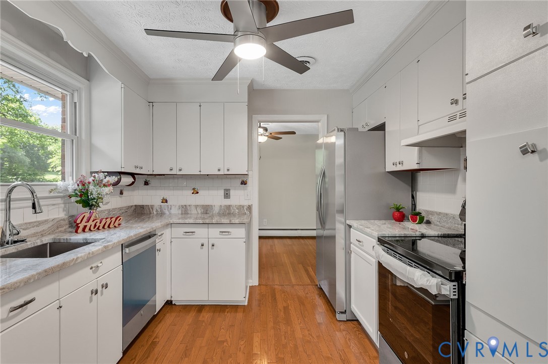 13101 Harrowgate Road Chester, VA 23831 - Photo 31 of 44 a kitchen with stainless steel appliances a sink dishwasher stove and white refrigerator with wooden floor