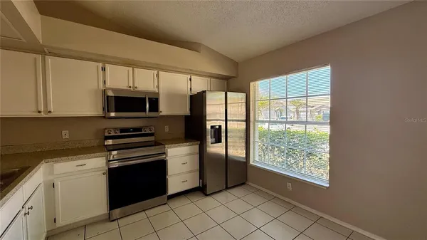 a kitchen with stainless steel appliances a stove sink and microwave