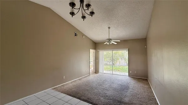 en empty room with windows and ceiling fan