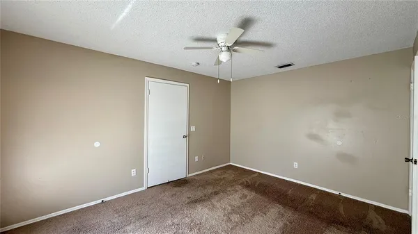 an empty room with a ceiling fan and a window