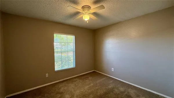 a view of a room with a window and a ceiling fan