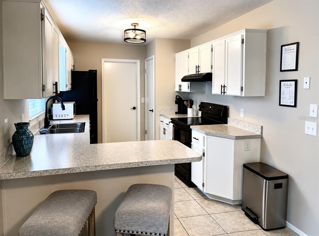 11177 Elgin Boulevard Spring Hill, FL 34608 - Photo 6 of 10 a kitchen with granite countertop a sink a stove and refrigerator