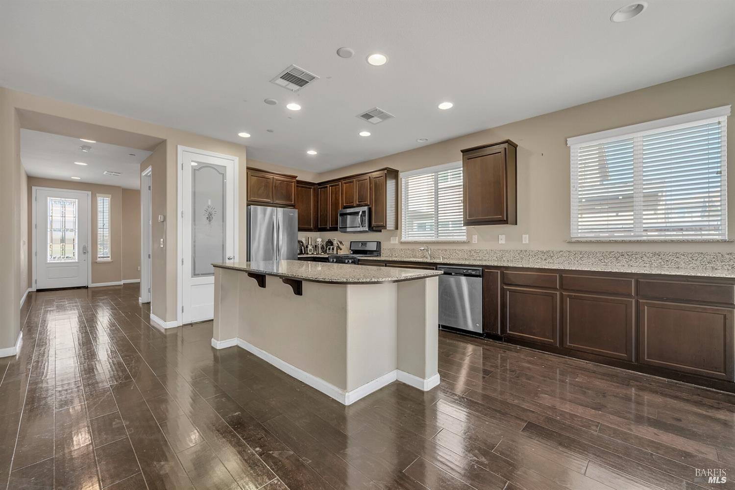 526 Epic Street Vacaville, CA 95688 - Photo 8 of 39 a kitchen with stainless steel appliances granite countertop a refrigerator a sink dishwasher a stove with wooden cabinets and floor