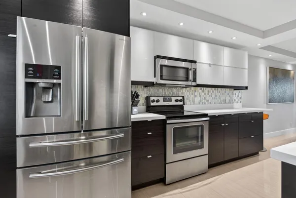 a kitchen with stainless steel appliances and refrigerator