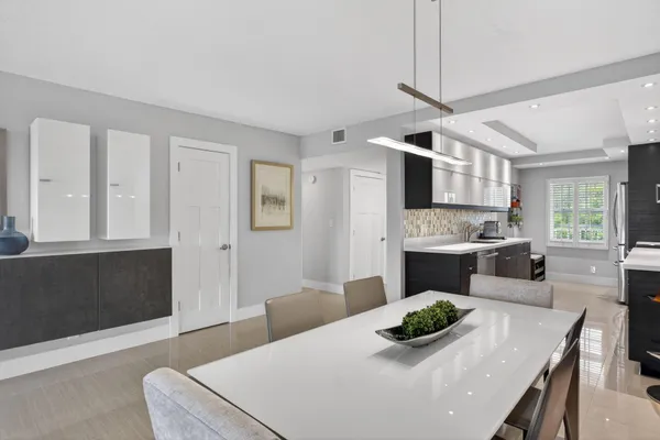 a kitchen with stainless steel appliances kitchen island granite countertop a table and chairs in it
